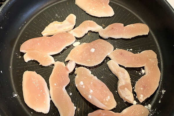 片栗粉をまぶした鶏むね肉を焼く